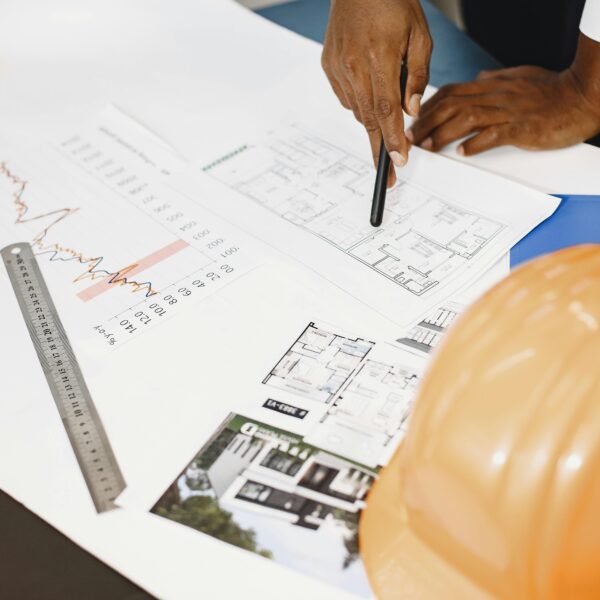 Architect analyzing building blueprints with tools on a desk, showcasing planning and design.